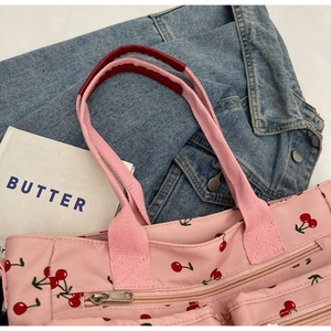 Detailed view of pink cherry print tote bag with multiple pockets and sturdy handles