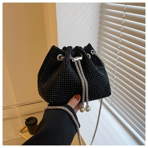Detail of black rhinestone bucket bag with silver chain strap and pearl charm accent