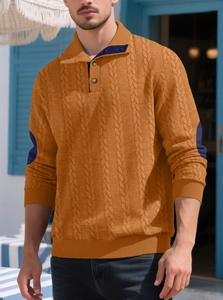 Detail of bright orange cable knit sweater with navy blue elbow patches and polo collar