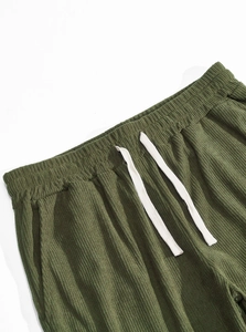 Detail of dark green corduroy jogger waist with elastic band and white drawstring
