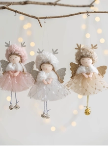 Close-up of mesh Christmas angel dolls with glitter wings and bells on tree branches