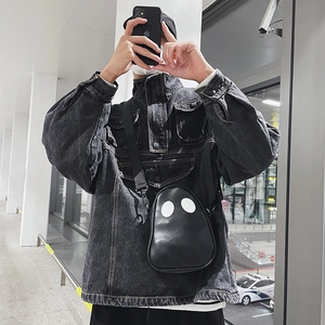 Close-up of a creative ghost-shaped black PU leather crossbody bag with white eye patches