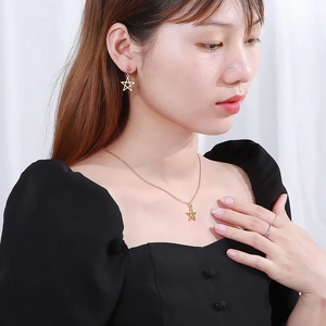 Minimalist gold star jewelry set with hollow pentagram necklace and earrings on a model