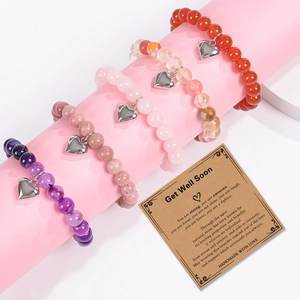 Natural stone bead bracelets with heart pendant and Get Well Soon card on pink display