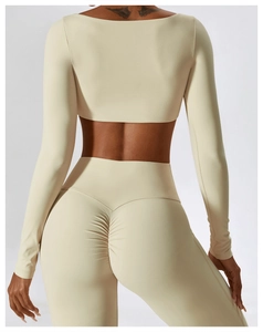 Gros plan du dos montrant les détails froncés sur le legging de sport beige crème