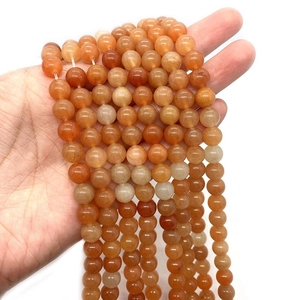 Natural round red aventurine stone beads held in hand for DIY jewelry making