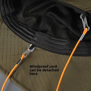 Detail of detachable orange windproof rope and breathable mesh lining on green hiking hat
