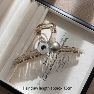 Detail showing 13cm champagne amber hair claw clip with floral and pearl accents