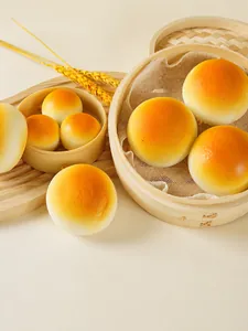 Realistic golden PU slow rebound steamed bun squishy toy inside a bamboo steamer tray