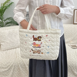 Detail of heart-quilted handbag featuring cute cat and puppy embroidery with slogan