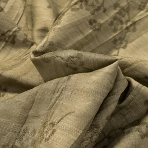 Detailed view of jacquard floral fabric with metallic sheen and soft textured folds
