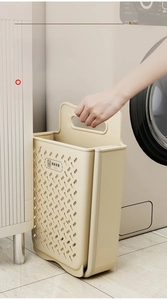 Slim folding laundry basket in beige PP plastic stored in a narrow washing machine gap