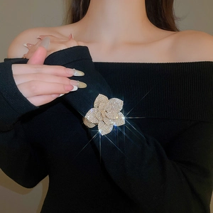 Macro shot of 3D crystal flower bracelet with sparkling rhinestones on black sleeve