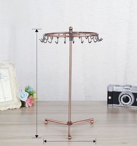 Rotating jewelry display stand showing adjustable height from 34cm to 48cm in bronze metal