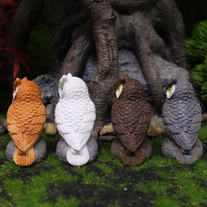 Set of four resin owl garden ornaments with realistic feather textures on stone base