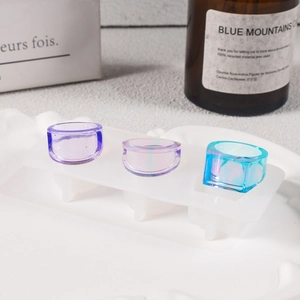 Nahaufnahme von geometrischen Harzringen in Lila und Blau auf einer Silikonform für DIY