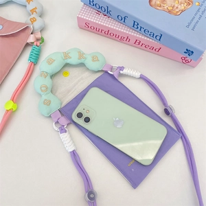 Detail of purple canvas phone bag featuring cloud-shaped mint strap with sozakka embroidery