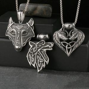 Detail of Viking wolf head and heart-shaped Celtic knot pendants in vintage steel