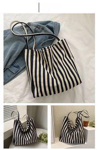 Detail of a blue and white striped canvas tote bag with slim shoulder straps