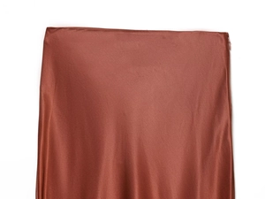 Detailed view of caramel satin skirt featuring an invisible side zipper and smooth texture