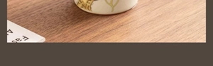 Detailed base of Ru kiln ceramic cup featuring delicate floral patterns on a wooden table