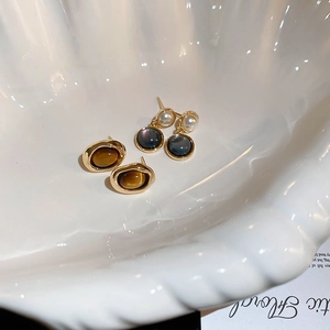 Vintage gold-plated oval faux tiger eye and pearl earring set in a ceramic shell bowl