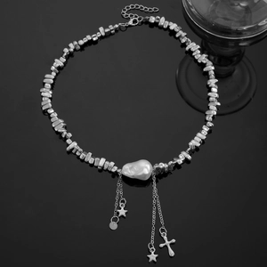 Détail du choker argenté avec perle baroque et pendentifs étoile et croix chic
