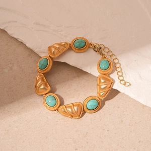 Detail of vintage gold bracelet with faux turquoise stones and triangle metal textures