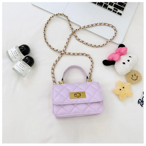 Flat lay of purple quilted mini crossbody bag with golden chain and playful accessories