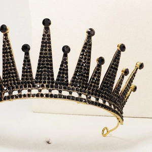 Detailed close-up of vintage black rhinestone crown with elegant gold metal frame