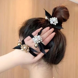 Elegant bow hair ties with pearls and rhinestones for women, shown in bun hairstyle