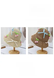 Close-up of wavy brim straw hats with crochet cherry accents and ribbon bows in two colors