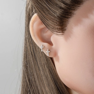 Gothic punk silver lace cross stud earrings worn by a model in a high-quality close-up