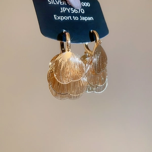 Detail of gold petal earrings showing brushed metal texture and S925 silver craftsmanship
