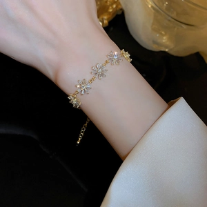 Macro view of gold daisy bracelet with sparkling white cubic zirconia and adjustable chain