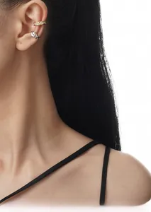 Detail of gold zircon ear cuff and silver irregular liquid metal cuff on female ear