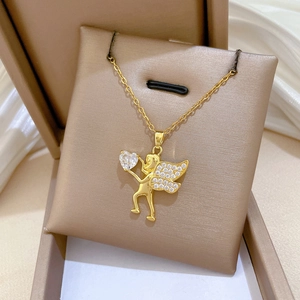 Detailed macro of gold angel pendant necklace with sparkling heart-shaped gemstone