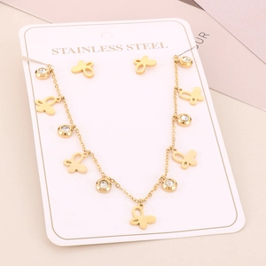 Detail of gold butterfly necklace and earrings set with crystal inlays on display card
