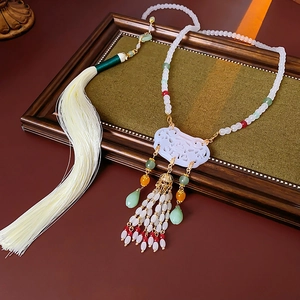 Detail of Chinese style pendant with white cloud carving, tassels and colorful beads