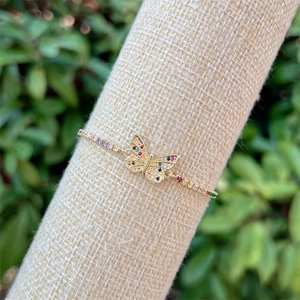 Macro detail of 18k gold plated butterfly bracelet with colorful zircon on burlap