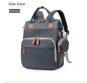 Detail view of dark grey diaper backpack with quilted pattern and round coin purse pouch