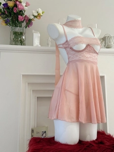 Dettaglio di sottoveste rosa in pizzo e mesh trasparente con gonna a pieghe e collarino