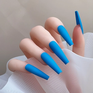 Gros plan d'ongles longs coffin bleu mat sur mains avec fond en tulle blanc léger