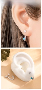 Detail of star-shaped earrings with blue opal and zircon stones on a model and ear display