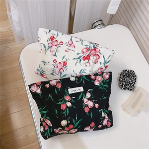Detailed top view of floral cotton makeup bags in black and white with tulip patterns