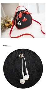 Detail shot of black litchi pattern bag showing red edges and a functional earphone hole