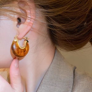 Gros plan sur des boucles d'oreilles en résine ambrée vintage avec base en métal doré