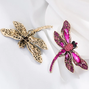 Macro detail of rhinestone dragonfly brooch showing front gemstone and vintage metal back