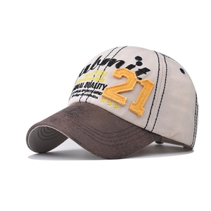 Detail of vintage baseball cap featuring orange number 21 patch and brown leather textured brim