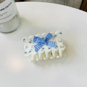 Detail of white hair claw clip featuring a blue checkered bow and cute cartoon rabbit